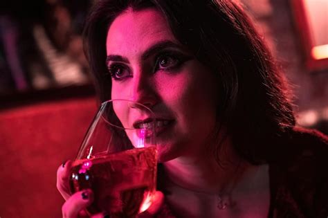 Premium Photo Happy Brunette Rebel Girl Sipping Drink On Vintage Armchair In Closeup Shot