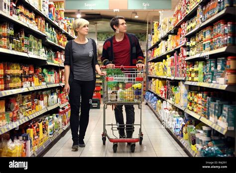 Jeune Couple Courses Au Supermarché Des étagères Avec Divers Produits