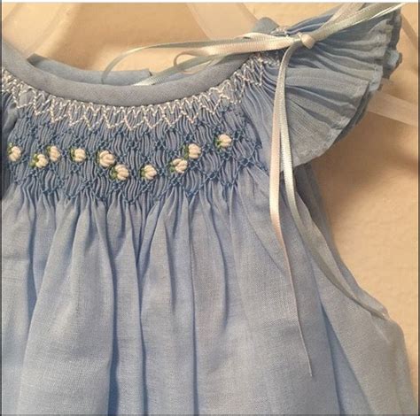 A Blue Dress With White Flowers On It And A Ribbon Around The Neck