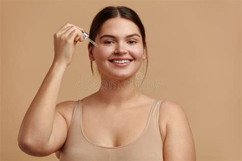 Woman Applying Serum On Face Woman Applying Essential Oil On Facial