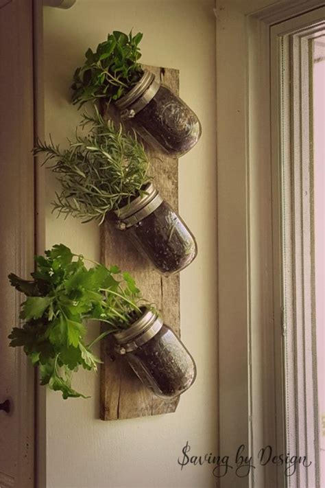 Three Mason Jars Filled With Herbs Hanging On A Wall