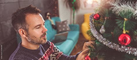 Men decorating Christmas tree Stock Photo | Adobe Stock