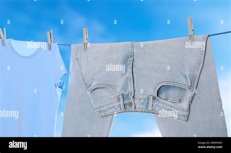 Jeans and t-shirt drying on washing line against blue sky, banner design Stock Photo - Alamy