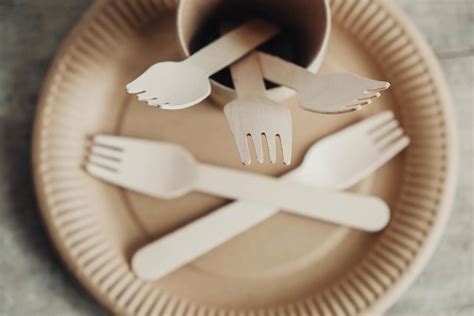 Wooden Forks And Paper Cups With Plates On Wooden Background