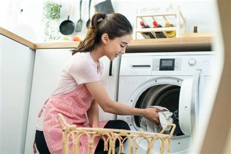 Asian Beautiful Woman Put Dirty Clothes To Washing Machine In House