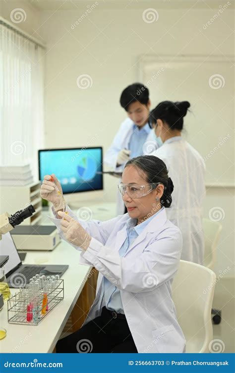 Professional Scientists Wearing White Coats Conducting Experiment In