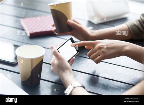 Two Beautiful Young Girlfriends Using App On Smartphone In Modern