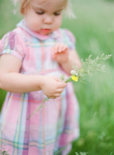 Young Girl Playing With Wildflowers And Field Grass By Stocksy