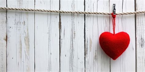 Premium Photo Red Heart Hanging On Clothesline On White Wooden Background