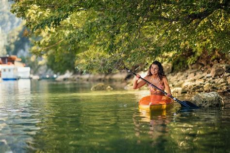 Premium Photo Female In Bikini Kayaking On Lake During Sunny Day