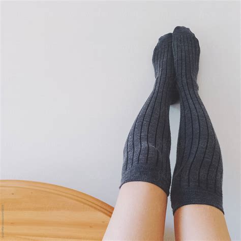 Woman Wearing Long Grey Socks Rests Her Feet On A Wall By Stocksy Contributor Jacqui Miller