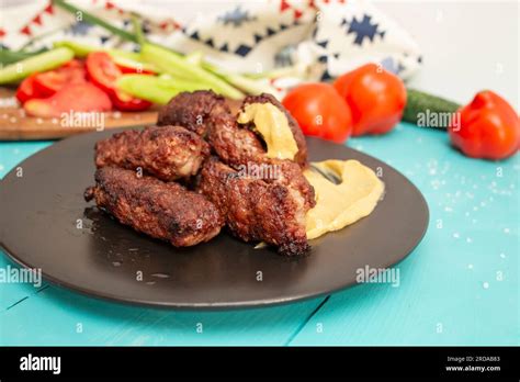 Kebapche Cevapcici Or Mici Mititei With Vegetables Side View On Blue