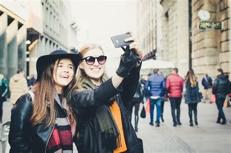 Premium Photo Two Women Taking Selfie With Mobile Phone In City