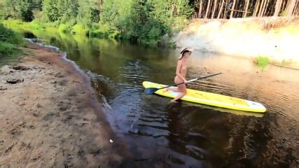 Tattooed Babe Strips And Swims On A SUP Board In The Forest River
