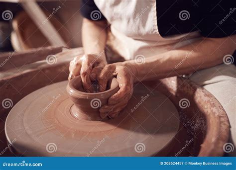 Close Up Of Female Potter Shaping Clay For Pot On Pottery Wheel In