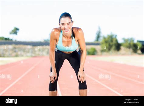 Tired Female Athlete Standing On Running Track Stock Photo Alamy