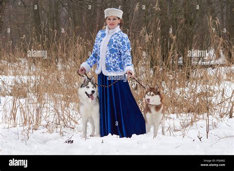 Young russian woman in traditional winter clothing with two Siberian ...