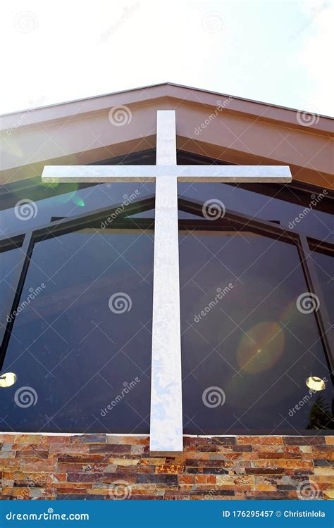 Large Silver Metal Cross Hanging On Steeple Of Christian Church