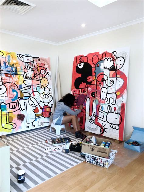 A Woman Is Sitting On The Floor In Front Of Two Large Art Pieces And