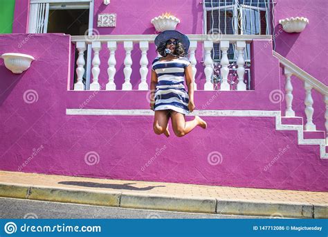 Una Mujer Africana Hermosa En Un Vestido Rayado Azul Y Blanco Que Salta