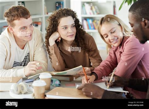 Multi Ethnic Group Of Smiling Young People Studying Together While