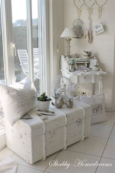 a living room filled with white furniture and lots of pillows on top of ...