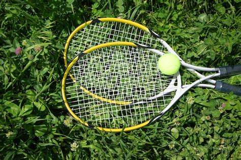 Premium Photo Tennis Ball And Racket On The Green Grass Background