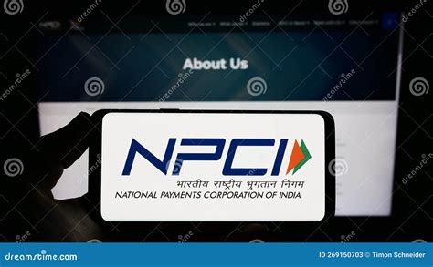 Person Holding Smartphone With Logo Of National Payments Corporation Of