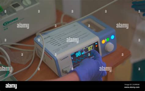 Pulse Oximeter Nurse In Blue Disposable Gloves Shows Explains The