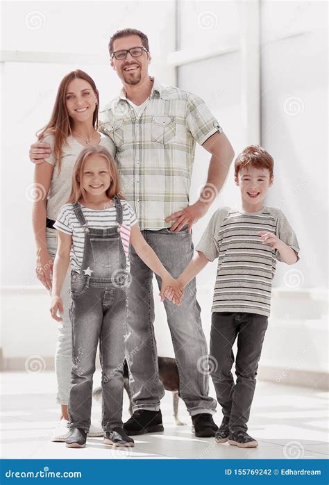 Familia Con Dos Ni Os Que Se Colocan En Una Nueva Casa Foto De Archivo