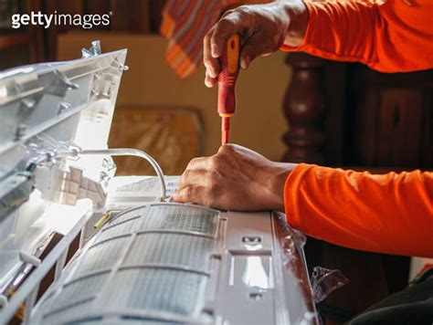 Hand Of Technician Use A Screwdriver To Tighten The Air Conditioning