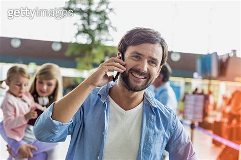 Portrait Of Mature Man Smiling While Talking On Smartphone In Airport