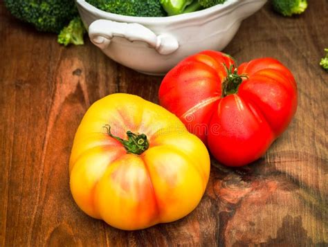 Whole Red And Yellow Heirloom Tomatoes On Wood Cutting Board Stock