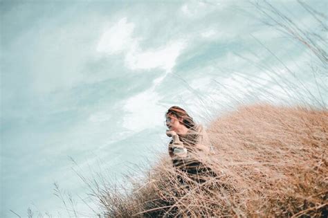 Premium Photo Young Woman Sitting On Grass Against Sky