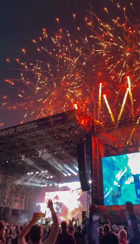 Fireworks Are Lit Up In The Night Sky Above A Crowd At An Outdoor Music