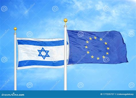 Israel And European Union Two Flags On Flagpoles And Blue Cloudy Sky