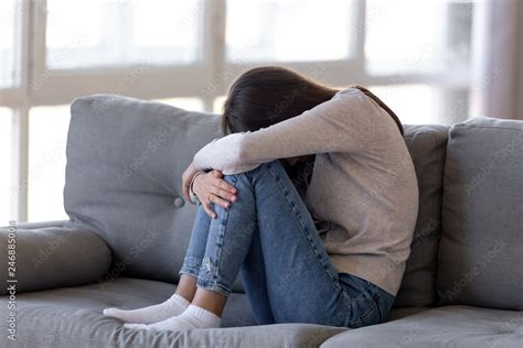 Depressed Teen Girl Sitting On Couch Feeling Anxious Ashamed Alone Sad