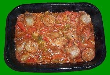 A Black Pan Filled With Food On Top Of A Green Table