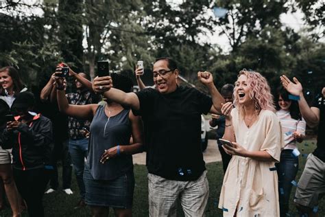 A Group Of People Standing Around Each Other With Confetti In Their