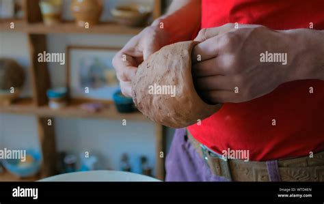 Professional Male Potter Examining Mug In Pottery Workshop Stock Photo