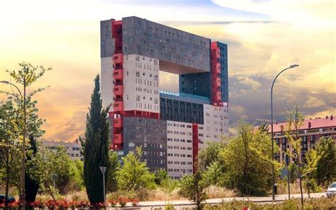 A Tall Building Sitting On The Side Of A Road Next To Trees And Bushes