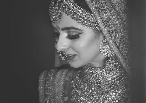 a woman in a bridal outfit with jewelry on her head and eyes covered by a veil