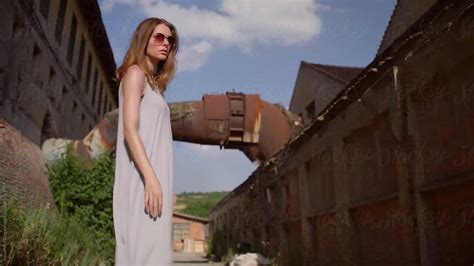 Woman In Grey Dress Walks In The Abandoned Factory By Stocksy Contributor Alexandra Bergam