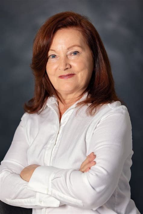 European Mature Woman Sitting At Table On Terrace Of Restaurant Drinking Milk Cocktail And