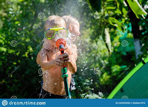 Joyful Boy Playing With Water The Boy In Hands Holds A Garden Hose