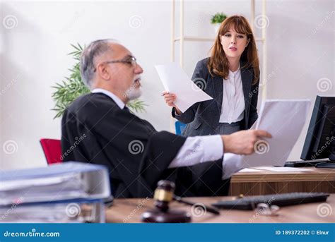 Old Male Judge And His Young Secretary In The Office Stock Photo