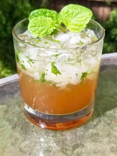 A Glass Filled With Ice And Mint On Top Of A Table