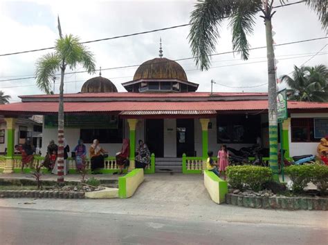 Some People Are Standing In Front Of A Building With Green And Yellow