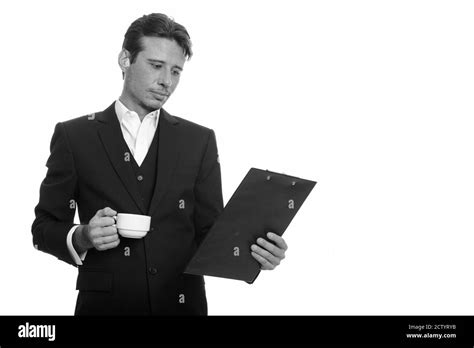 Handsome Caucasian Businessman Reading Clipboard While Holding Coffee