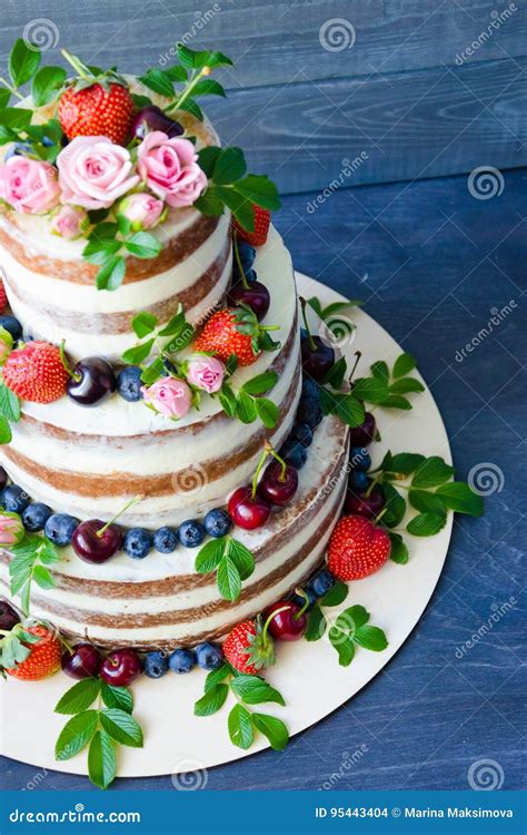 Naked Wedding Cake Decorated With Berries And Flowers Stock Photo